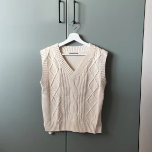 Stickad väst - Stickad väst i beige, aldrig använd