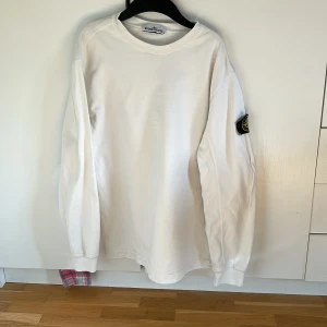 Stone Island Sweatshirt - Vit stone Island sweatshirt i okej skick, dessvärre 3 små fläckar på baksidan (bild 2) därav priset eftersom det är flaw. Går säkert bort i tvätten, inget jag testat. Storlek L men sitter mer som en M/L. Bara att skriva vid frågor eller funderingar! :)