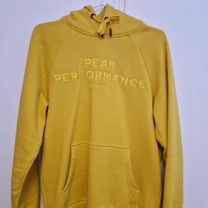 Peak Performance Hoodie Gul - Säljer min Peak hoodie i gul och storlek S. Köptes för 1100kr på VOLT, men har inte fått särskilt mycket användning sedan dess, därav vill jag sälja den. Fortfarande i utmärkt skick, så buda på bara!