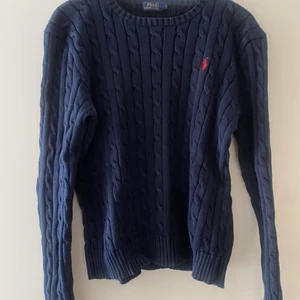 Polo Ralph Lauren Stickad tröja - Marinblå stickad tröja med rött märke. Slim fit. Strl XL (dam). Liten i storleken, passar även mig som har S/M. Nypris: 1500kr.