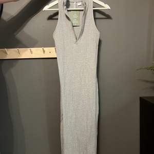 Grå långklänning från H&M med half zip och en liten slits i bak. Storlek S. Aldrig använd, prislapp kvar!!