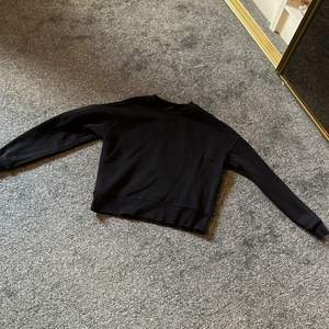 En svart sweatshirt som är bra i storleken. Längden är ungefär till höften.