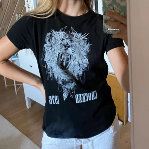 Svart T-shirt med tryck  - Skön T-shirt, använd men i fint skick.  Fraktar om köparen står för frakten, möjlighet till paketpris. 