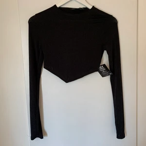 Oanvänd Nelly topp - Så snygg croppad långärmad tröja med en V-ringning nedtill. Säljes då den inte passar