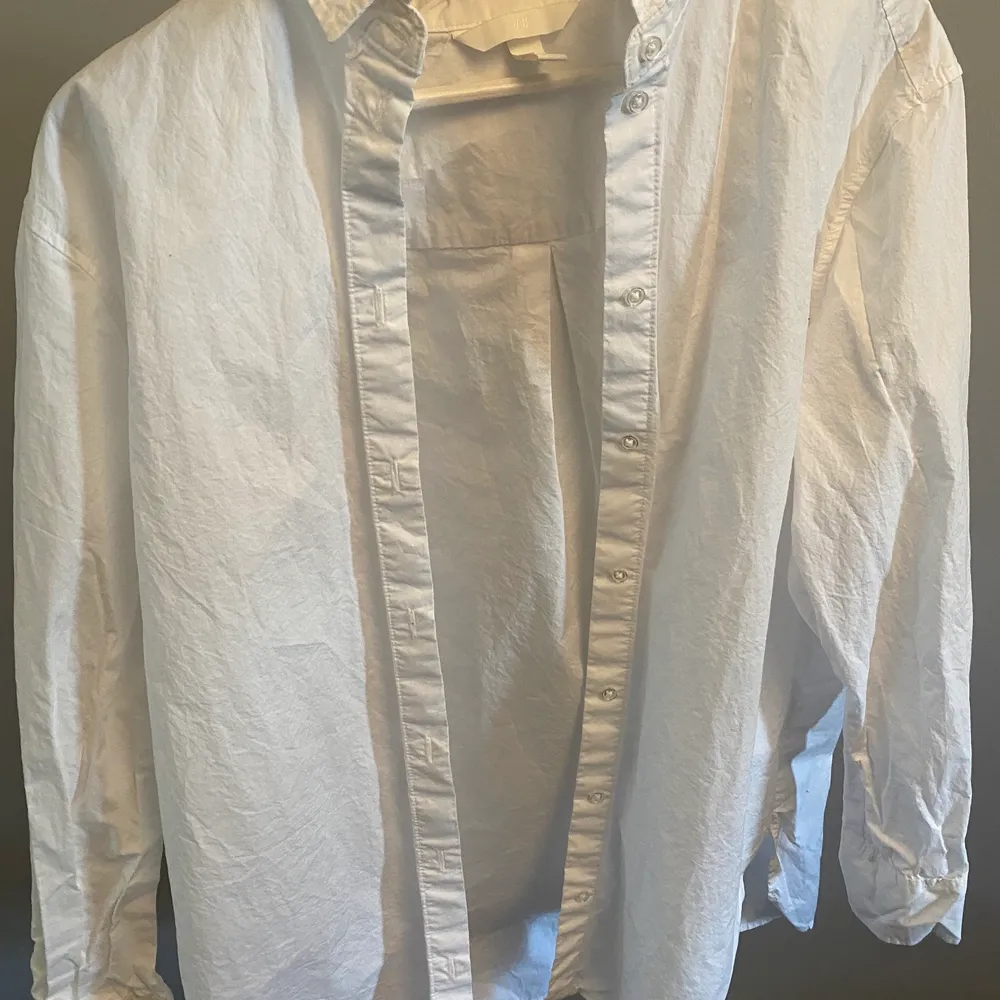 En vit skjorta. Använd en gång. Köparen står för frakten.. Skjortor.