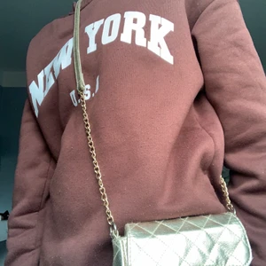 Guldig liten handväska - Väskan är väldigt gammal fast den är i bra skick. Den är väldigt liten.