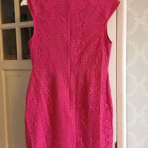 Bedårande djupt rosa klänning. Figursydd, 85 cm lång o ca 37 cm bred. Liten ståkrage