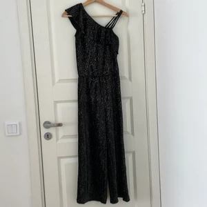 Svart one-piece - En glittrig svart one-piece som endast använts en gång. Den är köpt från Lindex och har storleken 146/152. 