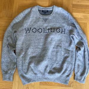 Woolrich sweatshirt i stickat material stl: L men ganska liten i storlek då den är lite för lite för mig som har medium.                                                                Köpt på Woolrich butiken i Stockholm för 1500 kr.          Är i mycket fint skick.                                                         Finns att hämta i Askim