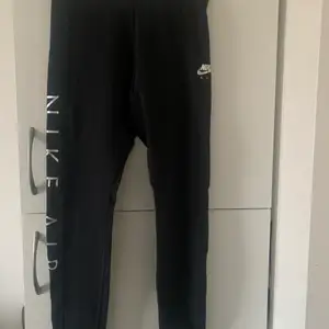 Nike air leggings i svart med silver text på höger fot. Storlek M