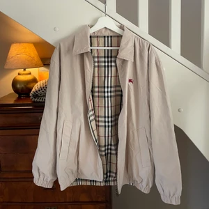 Burberry Jacka - Säljer denna klassiska jacka som är vändbar och  passar perfekt som vår- eller höstjacka. Använt mycket sparsamt och försiktigt så den är i gott skick. Köpte den begagnad för 2000 kr för ungefär två år sedan.