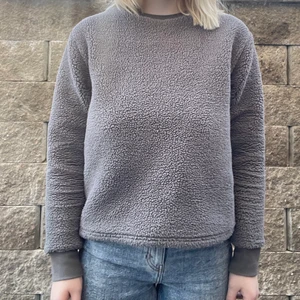 Teddy sweater  - Grå fluffig tröja i teddy-material! Denna tröja håller värmen ordentligt och funkar perfekt att dra på sig över tunnare kläder. Superbra kvalitet och skulle säga att den är i nyskick. 