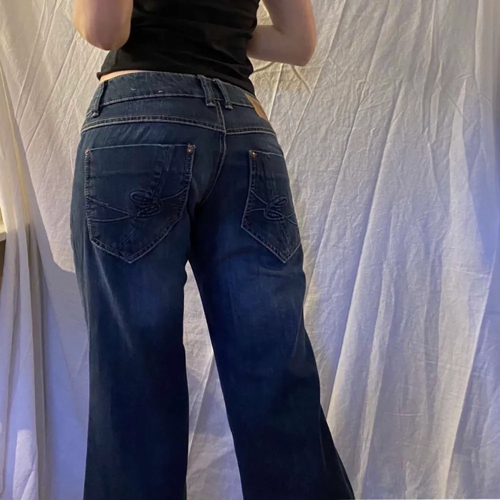 Skitsnygga lågmidjade vida/bootcut jeans. Så fina fickor både fram och bak! Säljer då de är lite för små😭 Modellen på bilden är ca 173cm lång, midjemåttet är 42cm och innerbenslängden är 82cm. Hör av dig vid frågor eller intresse!🥰💕. Jeans & Byxor.