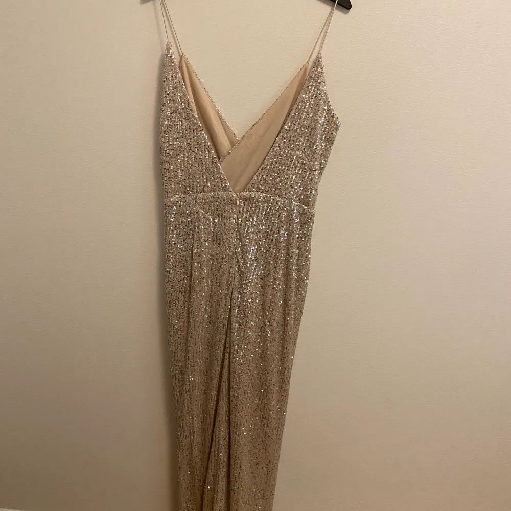 En glittrig champagnefärgad balklänning. Klänningen är V ringad och öppen i ryggen. Fram har den en slits och är superfin. Använd en gång.❤️ köpt för 1100kr. Klänningar.