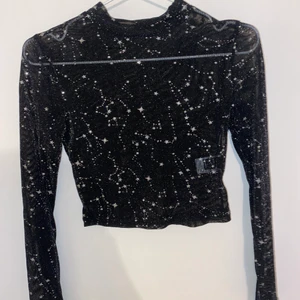 Festtopp - En svart nästintill genomskinlig topp i mesh. Storlek xs men stretching så kan passa S. Perfekt med en snygg spetsbrellette under. Stjärnor och stjärnbilder på. Inte fått användning av men är jättesnygg. Kan fixa bilder hur den sitter på.