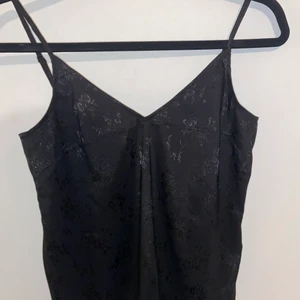 Linne - Svart linne med svart mönster. Hänger löst och material som lägge Stig fint. Sjusterbara band. Storlek 32/34. Jätte skönt men för litet på mig. Kan fixa bilder på hur den sitter på. 