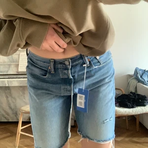 Levis shorts - Ett par långa levis short köpta på sellpy. Använt 0 gånger. Superfina med diskreta slitningar i vintage stuk. Går att både ha högmidjat eller hasa ner dom och få mellan/lågmidjat. 