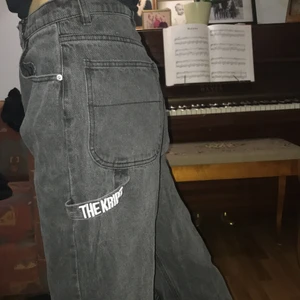 Svarta jeans med hål  - Säljer dessa svarta jeans från the kript som har en distressed look med hål. De är i väldigt gott skick och sitter väldigt högmidjat med många fickor. 
