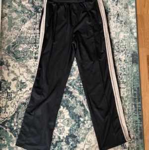 Our Legacy track pants - Our Legacy track pants. Storlek 48, vilket motsvarar medium. Bra skick. Nypris ca 2500. För fler bilder kan ni kopiera länken. https://bdgastore.com/products/track-pants-black-row-stripes