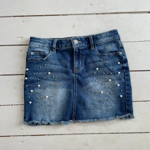 Jeanskjol med pärlor  - Väldigt söt jeanskjol med pärlor på! Sparsamt använd därav fint skick! 