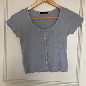 Gullig blå croppad tröja - Croppad blå tröja med knappar från brandy Melville i storlek one size!