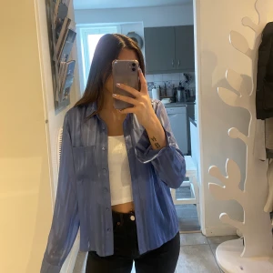 Blå skjorta - Skjorta i fint skick, aldrig använd bara provad. Säljer då den inte kommer till använing, går att användas både som pyjamas men oxkså att klä upp den:)