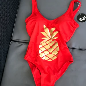 Röd baddräkt i nytt skick - Denna baddräkt har storlek smal möjligtvis medium, är osäker då jag ej prövat den. Baddräkten är röd men lite åt det oranga hållet. Det är ett tryck av en guldig annans på den samt finns det fastsydda inlägg som sitter på plats. Baddräkten har inte kommit till användning därav att jag köpte en annan som jag gillade mer. ❤️