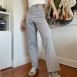 Beigea blåa vita kostymbyxor randiga 70s - Vintage 70-tals blå, vit, beige randiga högmidjade kostymbyxor 🎭 Desaa byxor har inte bara en så bra passform men också världens härligaste mönster! De två knapparna i midjan gör 70-tals viben ännu bättre och gör att de påminner om Harry Styles, så om du ska på hans konsert i sommar passar dessa perfekt ;) med en babytee och sneakers kan du gå på stan eller med en skjorta på fest! ;D skriv för mått! <3 