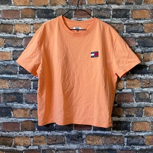 Peach färgad t-shirt - En fin tröja från märket Tommy Jeans. I fint skick. Färgen är peach. Storlek XL men passar som L. För mått eller fler bilder kontakta mig :) ‼️frakten är spårbar med PostNord‼️