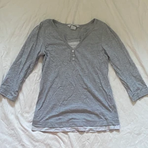 grå y2k milkmaid topp  - super söt grå milkmaid topp med 3/4 ärmar och kron tryck på baksidan. Barnstorlek men passar förmodligen XXS/XS. Har dessvärre en liten färg fläck på baksidan av ena armen. Osäker på om de går bort i tvätt. Kan skicka bild ifall de behövs.  Köparen står för frakt. 💕