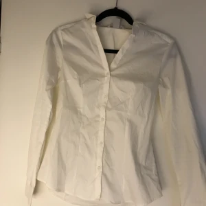 Skjorta - Fin basic skjorta med väldigt fin passform på kroppen. Urringad en aning men inte mycket.  Från H&M
