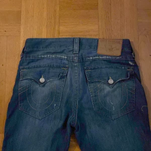 True religion jeans  - Säljer ett par true religion jeans jag köpte här på plick men tyvärr inte passade mig! De är bootcut och lågmidjade med ”slitningar” (hål)! Fråga om ni vill ha bättre bilder! Köparen betalar frakten :)