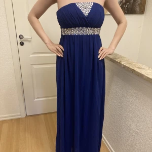 Blå långklänning - I sin helhet rätt enkel klänning. Detaljer kring bysten. Originalpris är 1090 kr. Skickar fler bilder vid intresse. 