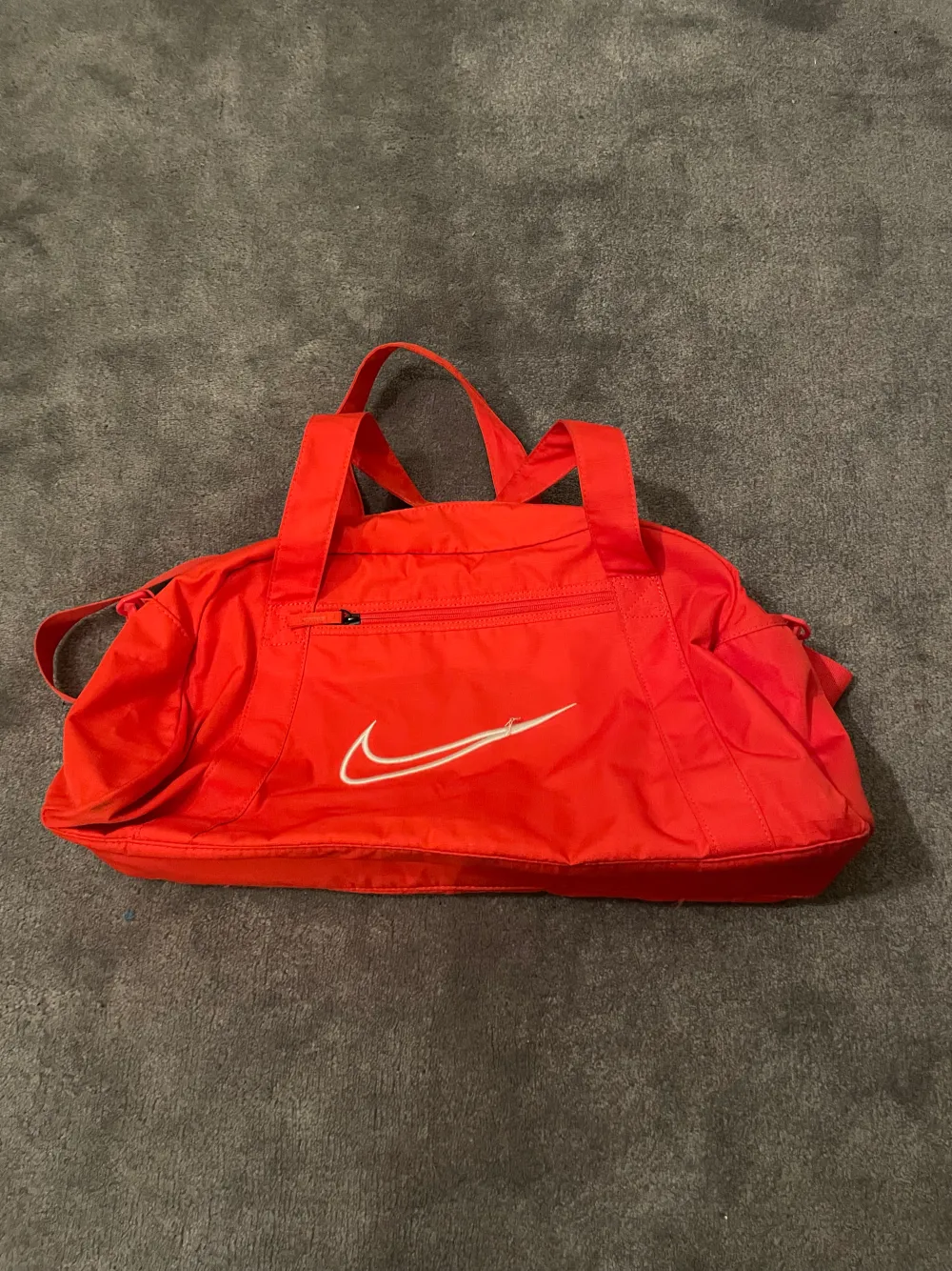 En stor röd sport väska. Väskan är knappt använd. . Väskor.