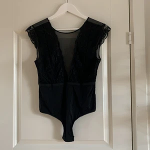 Spetsbody i storlek L - Svart spetsbody från pieces i storlek L. Knappt använd. Djupt v-ringad fram och bak. Andra bilden är tagen på baksidan.