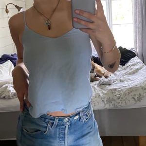 Ljusblå linne - Ljusblått/ vitt randigt linne, är lite V ringad.