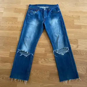 Ett par Levis jeans som är lite unika. Dem är klippta vid smalbenet och vänstra bakficka är urklippt  Storleken är 31/34 men jeansen är uppklippta så jag skulle säga att storleken är 31/32