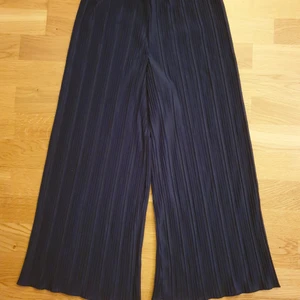 Mörkblå plisserad byxa - Mörkblå plisserad tunn byxa från Kappahl storleken är ca 164 ( lappen är bortklippt )