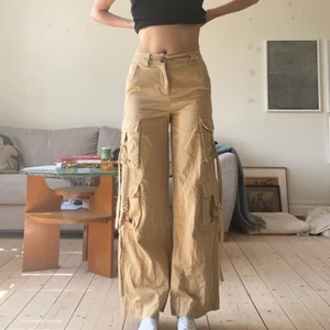Beiga cargobyxor! - Snygga cargobyxor med coola fickor på benen! Jag är 175 cm lång och har ungefär S i byxor! Dessa är strl XS men dem är stretchiga i materialet! Byxorna går även att sprätta upp en bra bit där nere så dem blir längre❣️💗💕