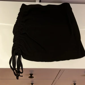 En svart kjol - En svart kjol, köpt på shein. Den är ribbad och har snörning på ena sidan. 