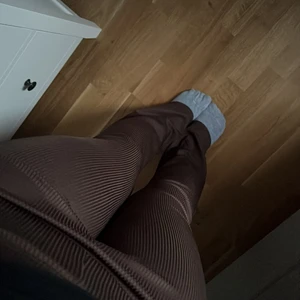 Bruna utsvängda byxor  - Ett par bruna utsvängda byxor, i tajts material dom är också ribbade. 
