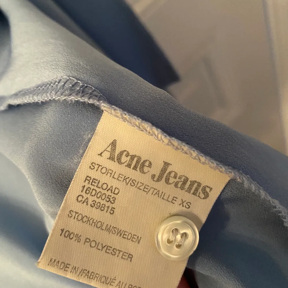 Blus från Acne Jeans med öppning och knytning bak. Fin blå färg! Knappt använd. Säljer pga för liten.. Blusar.
