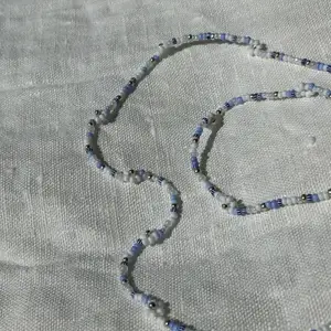 Pärlat halsband och armband i olika blåa färger 