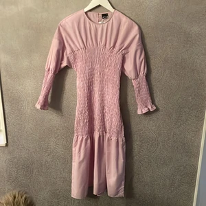 Oanvänd Gina klänning - En helt oanvänd Gina tricot klänning som har hängt i garderoben det senaste året. Lapparna sitter till och med kvar. Säljer den nu för att jag tycker den sitter otroligt fult på mig. Färgen är lila/ rosa och klänningen är stretchig i mitten samt på armarna. På rätt person är den otroligt snygg. Nypris är 600kr 