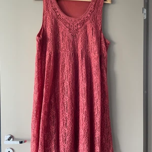 Klänning  - Aldrig använd. Rost orange ärmlös klänning. Brodyr med ett tyg under. Under kjol som är lite längre. 