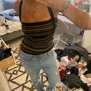 Topp - En guldig svart randig topp som man kan styla på lite olika sätt!  Storlek S