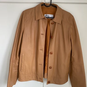Brun läderjacka - Ljusbrun läderjacka köpt här på Plick. Uppskattar storleken att vara runt S, men passar även XS och M. Använd, men i bra skick. 