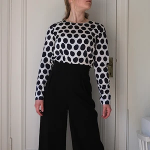 Blus, storlek 34 - Vit blus men blåa prickar i glansigt material (polyester) i storlek 34. Fin både till vardags och finare sammanhang. 