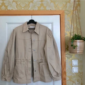 Carin Wester Jeansjacka beige  - Hejsan!! Underbart fin jacka till sommaren. Storlek 40. Passar 38-42. Knytband i midja. Djupa fickor som rymmer mycket. Sparsamt använd. 