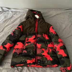 Moncler eymeric camoflauge  - Väldigt cool och sällsynt Moncler jacka för den som vill sticka ut från mängden. Storlek 3/M. Nypris 16 000:-